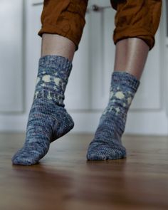 a person standing on the floor wearing socks with holes in them