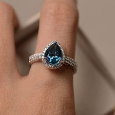 Blue topaz ring pear engagement ring sterling silver pear | Etsy Silver Halo Teardrop Rings, Silver Teardrop Halo Rings, Elegant Topaz Teardrop Rings, Silver Pear-shaped Ring With Halo Setting, Teardrop Halo Ring For Anniversary, Formal Teardrop Topaz Rings, Teardrop Topaz Ring With Accent Stones For Anniversary, Blue Topaz Teardrop Promise Ring, Anniversary Teardrop Topaz Ring In Sterling Silver