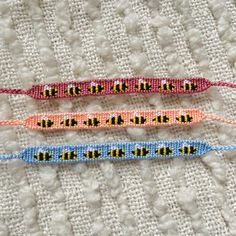 three beaded bracelets sitting on top of a white cloth next to each other