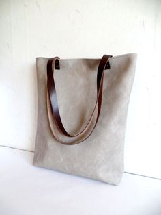 Large vegan/faux leather tote - light grey vegan/faux leather everyday tote bag. * Exterior: - High quality vegan/faux leather in gorgeous dove grey / light grey color * Interior: - 100 natural cotton in corresponding grey and white polka dot pattern * Two inside slip pockets * Real leather handles in dark chocolate brown attached with antique toned brass rivets * Closes with magnetic snap closure reinforced with natural leather Measurements: Height: 15 inches Width of the bag: 13 inches Length Taupe Tote Bag With Leather Handles, Taupe Leather-handled Tote Shoulder Bag, Gray Tote Shoulder Bag For Everyday Use, Gray Bags With Leather Handles For Everyday Use, Gray Shoulder Bag With Leather Handles For Daily Use, Gray Bags With Leather Handles, Gray Bags With Leather Handles For Daily Use, Modern Gray Shoulder Bag With Leather Handles, Gray Leather Shoulder Bag For Everyday Use