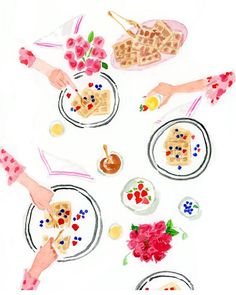 an image of people eating food at a table with plates and flowers on the table