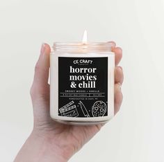 a hand holding a candle that says horror movies and chills on it in front of a white background