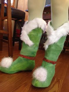 someone is wearing green boots with white fur on the bottom and one foot in high heels