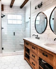 a bathroom with two sinks, mirrors and a walk in shower next to a toilet