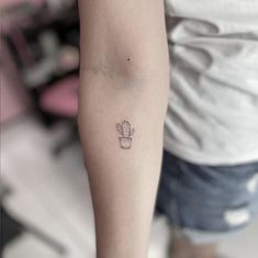 a small cactus tattoo on the left inner arm and leg, with an outline of a plant in it