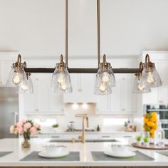 a kitchen island with four lights hanging over it