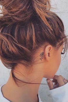 a woman with a tattoo on her left side of her neck and behind her ear