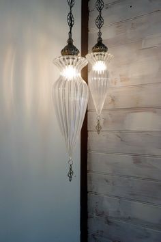 two lights hanging from the side of a wall