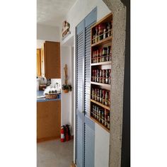 an open door leading into a kitchen with lots of spices on the shelves