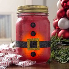 a mason jar decorated with santa claus's belt and gold glitter on the lid