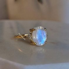 "Most Welcome to \"TheJewelryArts\" Products Description Center Stone: Genuine Rainbow Moonstone Center Stone Size: 10x12mm Stone Shape: Oval Cut Side Stone: Cubic Zircon Stone Clarity: VVS Material: 92.5 Sterling Silver, also available in 24k Rose Gold Vermeil/Gold Vermeil/Black Vermeil Stamp: 92.5 ➽OCCASION: Surprise your loved one with this beautiful engagement/wedding jewelry by TheJewelryArts . A classic piece of jewelry for all men/women in your life, this is a perfect gift for any occasion such as birthdays, anniversaries, wedding, engagements, Valentine's Day or Christmas day mother's day. ✔Comfort Fit ✔Nickel Free ✔Free Engraving ✔ Free Shipping ✔  Ready to Ship in 3 Business Day Customization is always welcome and please feel free to contact with me if you have any design ideas! White Stone Ring, Jewelry White, Rainbow Moonstone Ring, June Birthstone, Moonstone Ring, June Birth Stone, White Stone, Summer Jewelry, Perfect Ring