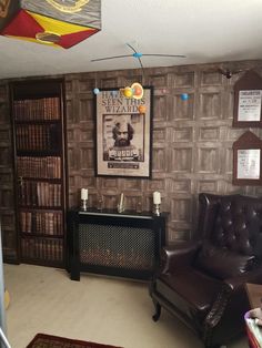 a living room filled with furniture and bookshelves next to a wall covered in posters