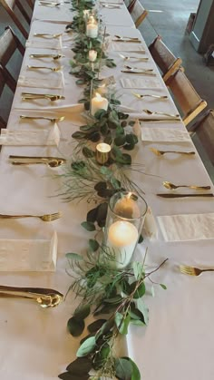 a long table is set with candles and greenery for an elegant dinner or party