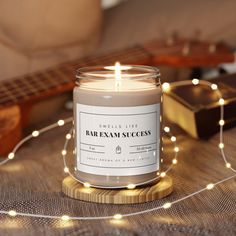 a candle sitting on top of a table next to a string of lights and a guitar