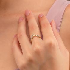 a woman wearing a diamond ring on her left hand