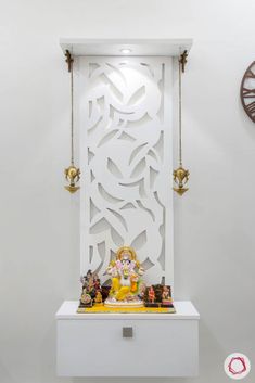 a small shrine with statues on it and a clock in the backgrouund