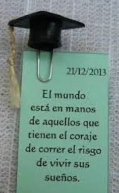 a graduation cap hanging from the side of a green sign that reads el mundo est en manos de aguelos que tien el coraje