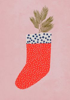 a christmas stocking with a pine branch sticking out of it's side on a pink background