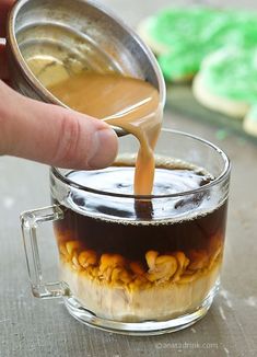 a person pouring coffee into a glass mug with peanuts in it and the caption reads, fel kellkehene? a kavenmak