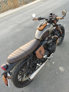 a motorcycle parked on the side of the road in front of a fenced area