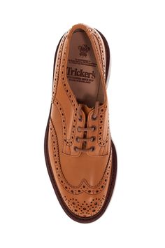 The Bourton derby lace-up shoes by Tricker's are made of antiqued Acorn leather with brogue punching and a gusseted tongue sewn to the shoe. The lining is full-grain leather, while the insole features padded heel support. They have a Goodyear construction with waterproof stitching, a full-grain leather midsole with cork padding, and a studded Dainite rubber sole. Composition: 100% calfskin Brown Goodyear Welted Lace-up Derby Shoes, Brown Wingtip Lace-up Shoes With Leather Lining, Cognac Goodyear Welted Wingtip Oxfords, Cognac Leather Shoes With Brogue Detailing For Derby, Cognac Leather Brogue Shoes For Derby, Cognac Goodyear Welted Wingtip Leather Shoes, Cognac Oxfords With Brogue Detailing Cap Toe, Cognac Wingtip Dress Shoes For Derby, Cognac Cap Toe Oxfords With Brogue Detailing