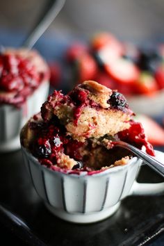 blueberry muffins in a white bowl with a bite taken out of it