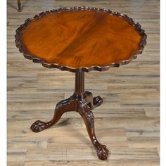 an ornately carved wooden table sits on the floor in front of a wood floor