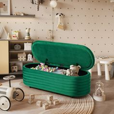 a green toy chest sitting on top of a wooden floor next to toys and decor