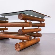 a table made out of wood sticks and glass tabletop on top of each other