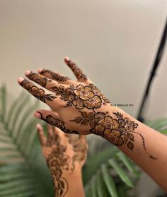 two hands with henna tattoos on them