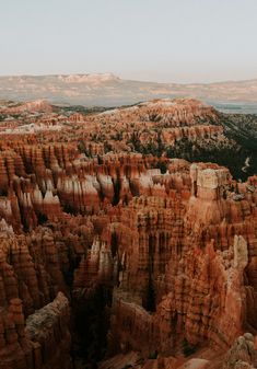 an aerial view of the hoodoos and canyons in the distance with mountains in the background