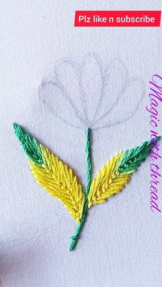 a close up of a piece of embroidery on a white shirt with green and yellow leaves