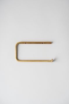 a metal object on a white surface with a gold colored handle that is shaped like a rectangle