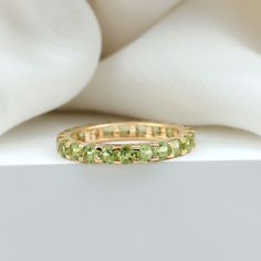 Product Details Celebrate your bond of eternal love with this Eternity Band Ring adorned with round shape Peridot. This Stackable Ring makes for a trendy choice for marking the special day of your life. Product Information SKU SHP-RINGS042166036 Width 2.5 mm Height 2 mm Weight 1.60 gm (Approximate) PERIDOT INFORMATION No.of Stones 25 Pieces Total Weight 4.00 Carat (Approximate) Dimension(approx) Round-3X3 mm-25 Pcs Color Green Cut Brilliant Shape Round Setting Type Shared-Prong-Setting Quality G Gold Rings Stackable, Eternity Band Ring, Peridot Ring, Jewelry Lookbook, 18k Yellow Gold Ring, Green Peridot, Stackable Ring, Eternal Love, Eternity Band