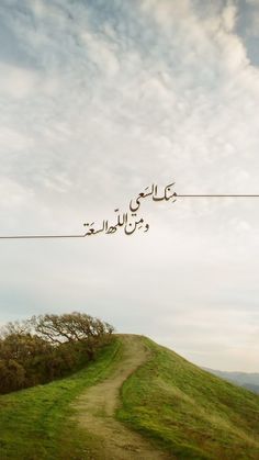 an image of a path going uphill with arabic writing on the sky above it