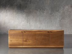 a large wooden cabinet sitting on top of a cement floor next to a concrete wall