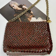 This vintage Whiting & Davis handbag from the 1970s is a must-have for any vintage fashion lover. Made from tortoiseshell mesh, this shoulder bag is both stylish and practical. The red/brown tones of the mesh give it a unique and timeless look. This original piece is in excellent condition and has been well preserved. It features the Whiting & Davis logo on the inside and is made in the United States. Perfect for any occasion, this bag is a statement piece that is sure to turn heads.  All mesh t Vintage Crossbody Bag With Chain Strap, Vintage Shoulder Bag With Chain Strap For Everyday Use, Vintage Chain Strap Shoulder Bag For Everyday Use, Vintage Shoulder Bag With Chain Strap, Vintage Gold Crossbody Shoulder Bag, Vintage Red Rectangular Shoulder Bag, Vintage Square Shoulder Bag With Gold-tone Hardware, Vintage Shoulder Bag With Gold-tone Hardware For Party, Vintage Shoulder Bag Clutch With Chain Strap