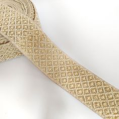 a close up of a tie on a white surface with gold glitters and beads