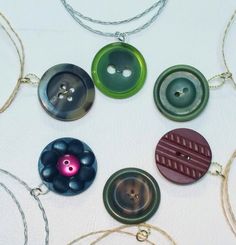 several different colored buttons are attached to necklaces