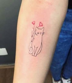 a cat with hearts on its tail is sitting next to a woman's arm