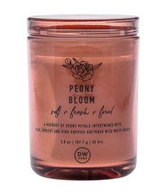 a pink candle that is sitting on a white surface with the words peony bloom in it