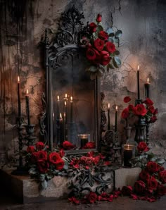 an ornate mirror with candles and roses on the table in front of it, surrounded by red flowers