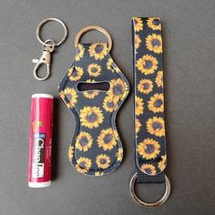 a keychain with a sunflower print and a lighter next to it