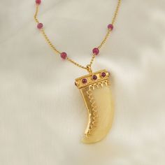 The belief and the motif of the 'claw' both transcend time and geography, and have seen multiple adaptations tying in with mystic beliefs. Drawing on this storied motif, here's our adaptation of it in this pendant worked on yellow quartz, detailed with gold and rubies. The pendant is strung on a gold chain interspersed Yellow Quartz, Heirlooms Jewelry, Unique Jewelry Designs, Amulets, Evil Eye Bracelet, Adaptation, Vintage Charms, Jewelry Branding, Geography