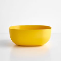 a yellow bowl sitting on top of a white table