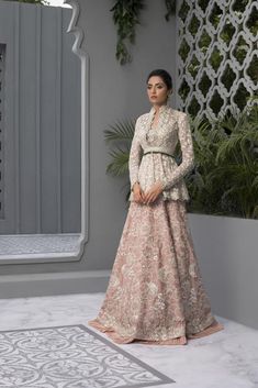 The modern peplum is crafted from embroidered net with beaded detailing and a cutwork bordered neckline. It is seen paired with our tissue choli and worked, beaded belt. The blush pink khaddi silk lengha offsets the piece with its striking floral motif embroidery. ItΓÇÖs a piece that will stand out through its poetic d Silk Lengha, Wheat Rice, Pakistani Lehenga, Lavish Wedding, Mehndi Outfits, Motif Embroidery, Beaded Belt, Silk Lehenga, Cut Work