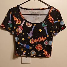 Awesome Sailor Moon Crop Top! The Garment Features Wands, Stars And Sailor Moon Text In An All Over Print. It's Made With 95% Polyester And 5% Spandex. There Are No Flaws To The Shirt. The Measurements Are: Pit To Pit: 15 Inches Length Of Top Of Neckline To Bottom Hem: 16 Inches. Sailor Moon Crop Top, Fitted Black Cartoon Print Tops, Fitted Black Top With Cartoon Print, Fun Black Printed Top, Trendy Black Top With Moon Print, Casual Multicolor Star Print Top, Casual Multicolor Tops With Star Print, Fitted Moon Print Crew Neck Top, Fitted Black Tops With Moon Print