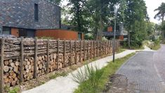 a large pile of logs sitting on the side of a road next to a building