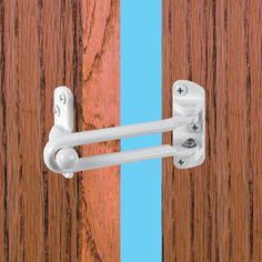 an open door with two white handles on the front and side of it, against a wooden background