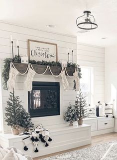 the living room is decorated for christmas with white furniture and greenery on the mantle